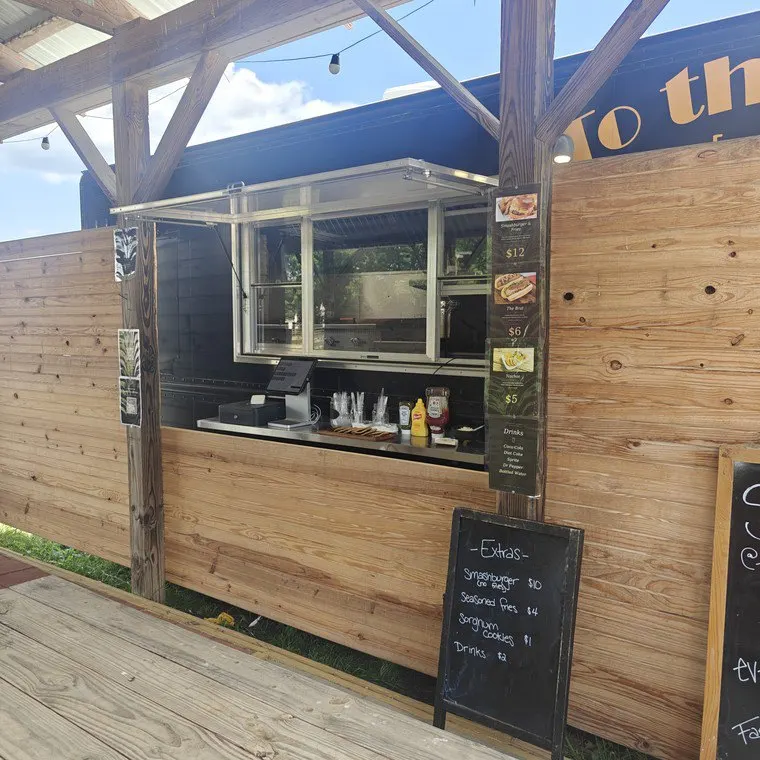 An open food-truck serving window beneath a timber shelter.